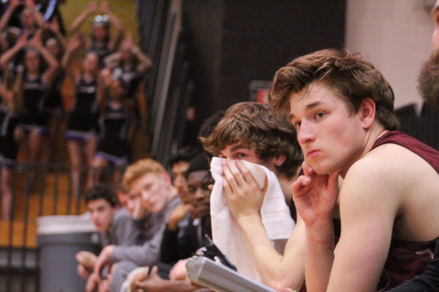 Senior Sam Tunney watches from the bench during the game.