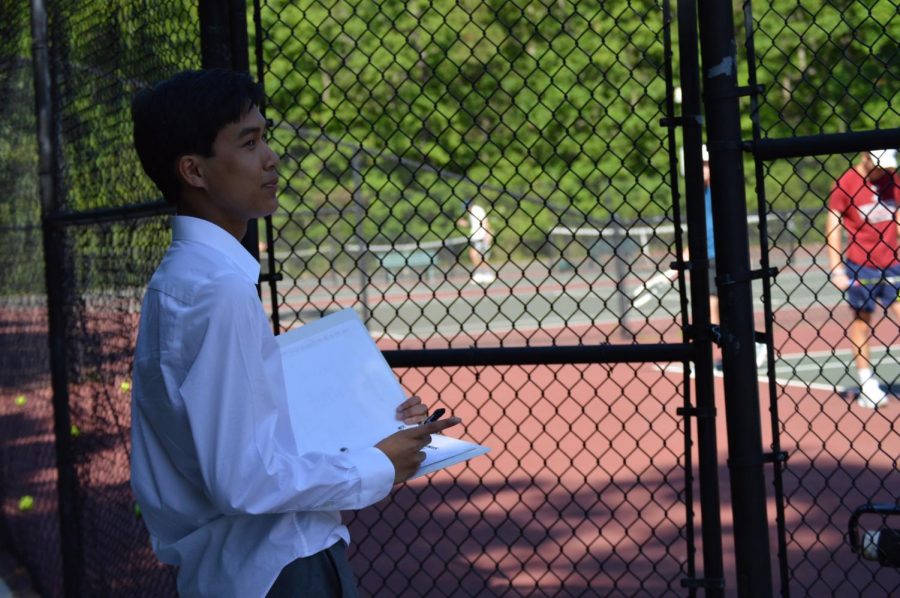 Andrew Nguyen watches over the tennis team as they perform.