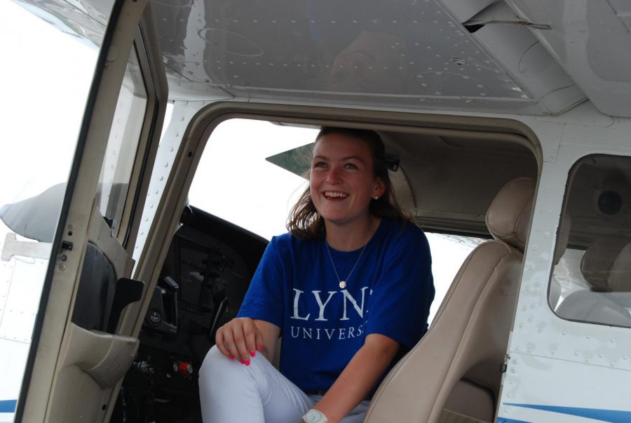 Addison Terry sits in the cop pit of a plane in preparation for a flight.