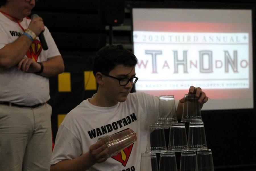 Freshmen Connor Bosse does a miniature cup building challenge to raise money for Shawn Jenkins. 