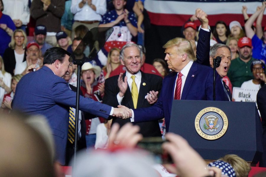 President Donald Trump shakes the hand of Drew McKissick, chair of the Republican party in South Carolina, as Governor Henry McMaster and Ralph Norman look on.  