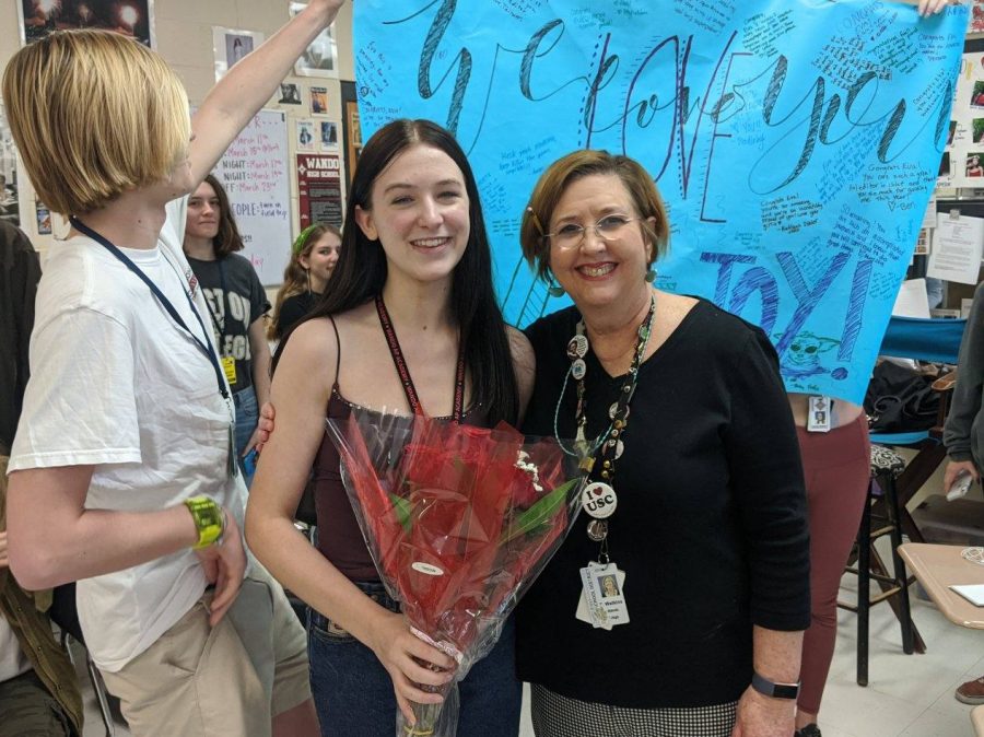 Co-Editor in Chief Eva Chillura and Adviser Tamela Watkins smile next to a congratulatory banner made by Tribal Tribune staff.