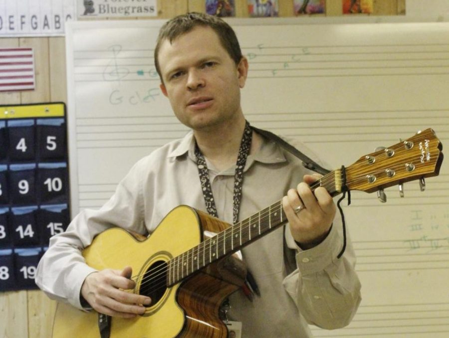 Derek Deakins plays his guitar in his trailer classroom at Wando. At the school, he teaches music theory and guitar, and also conducts the Wando High School Orchestras.