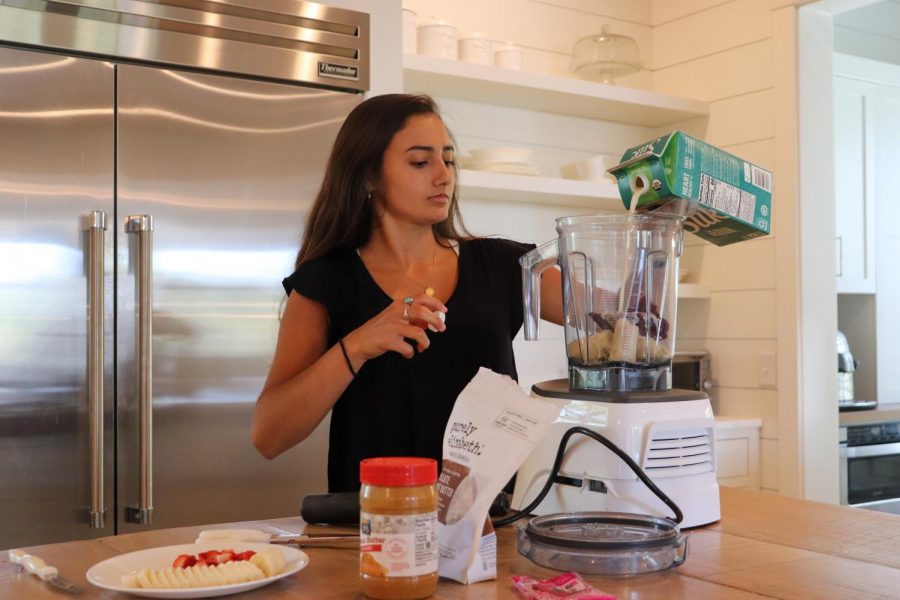 Ava Elliot pouts Silk milk into her blender.