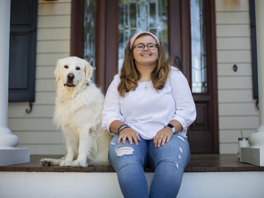 Merritt Redden sits on her porch with her dog.