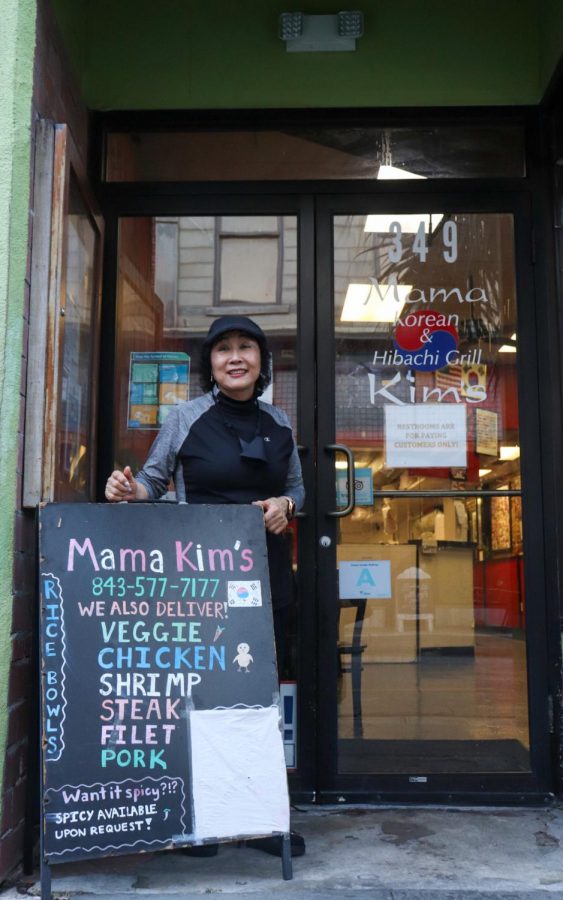 Mama Kim stands in front of her restaurant 