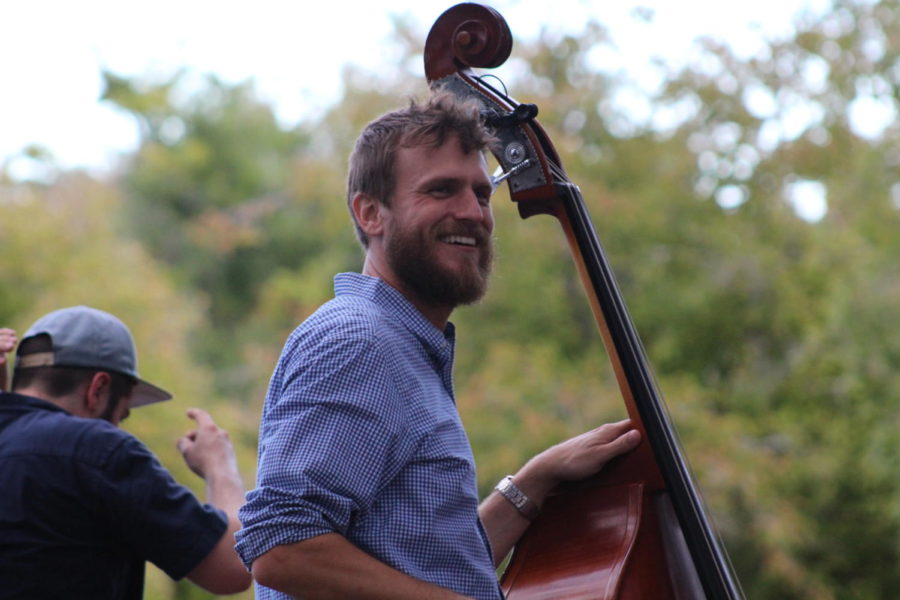 Anthony Del Porto from The Pluff Mud String Band smiles at the crowd while playing his bass.
