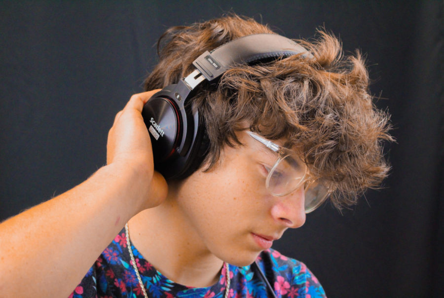 Senior Micah Bradburn listens to music on his headphones. He uses these headphones when he is recording music in his recording studio that he made.