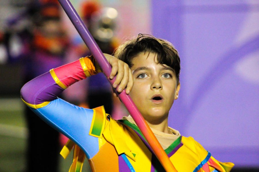 A member of the color guard holds his flag while looking into the audience.
