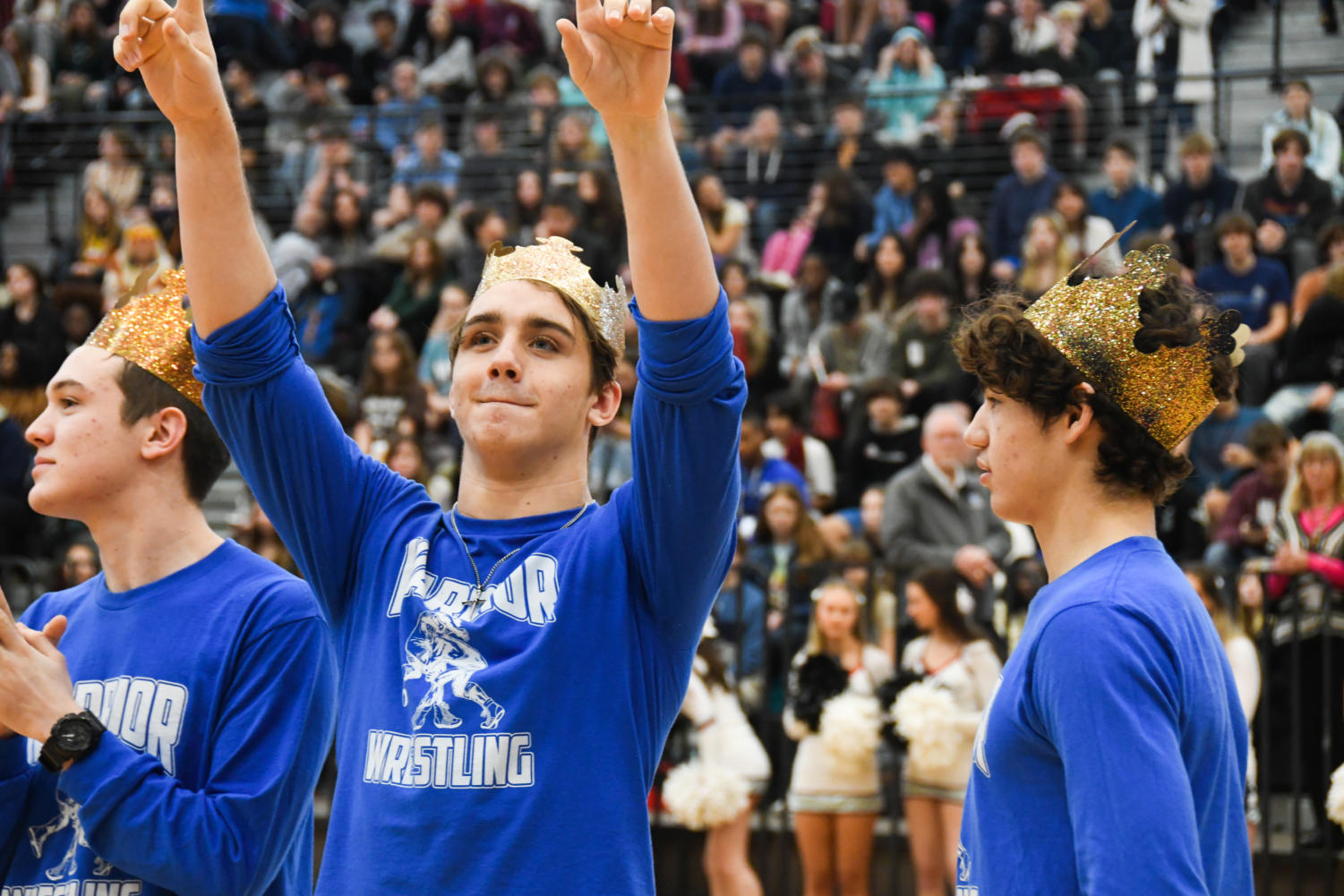 Senior Jacob Pelbath, member of the wrestling team, points to the crowd while they cheer for him.