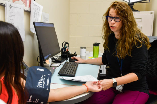 Nurse Andrea Urbanski checks a students vitals and discusses the students health.