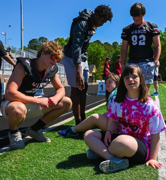 Exceptional Education athlete Taryn Uyak poses with members of the football team at this year’s Special Olympics. “I won that race that day; I feel happy,” Uyak said.