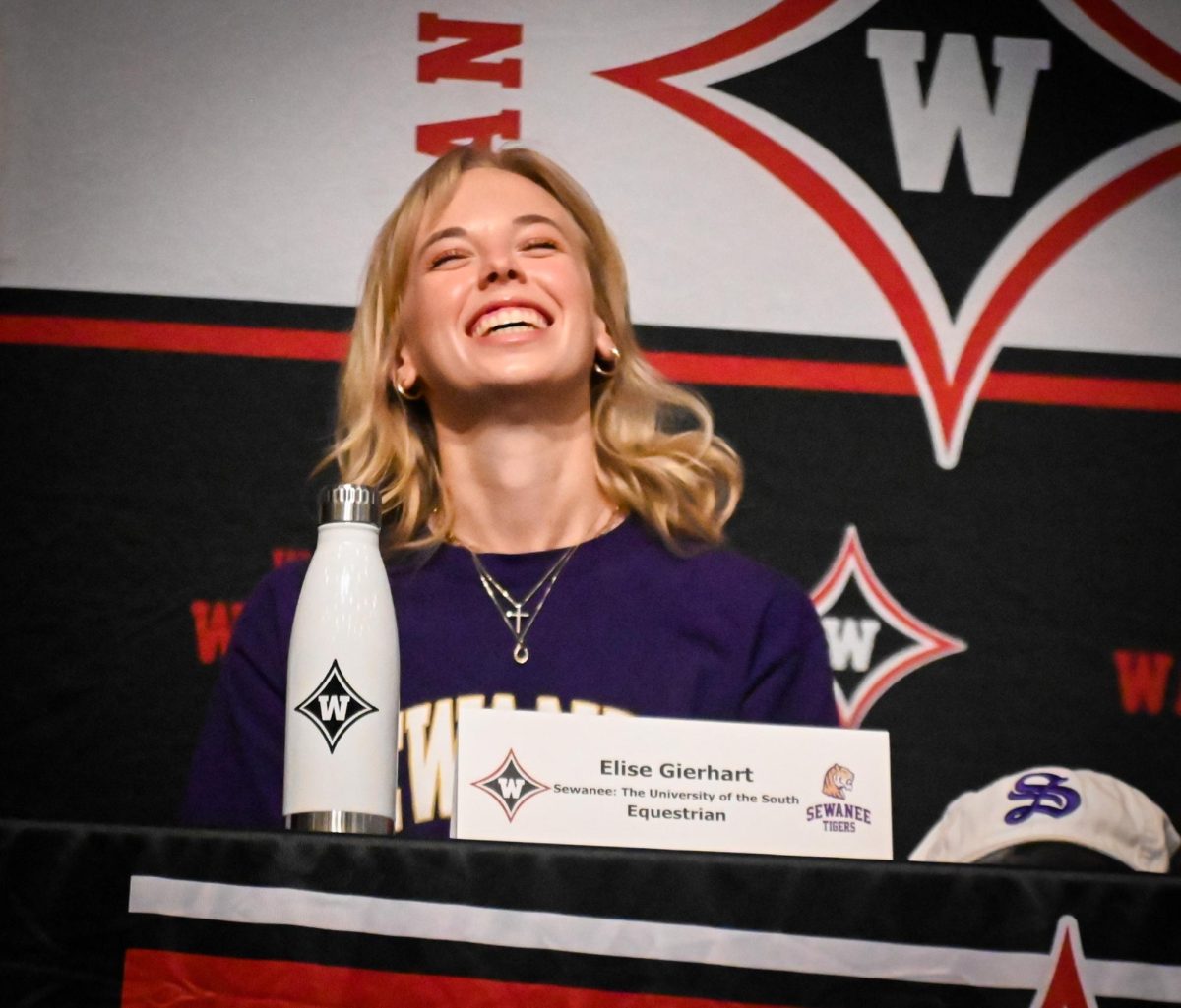 Gierhart sits at the signing day table on April 17 listening to her coach talk about her as an athlete. “I was really happy to be there, it was a very full circle moment [and] I got to be there [with] my coach,” Gierhart said. Gierhart will join the horseback riding team at Sewanee.