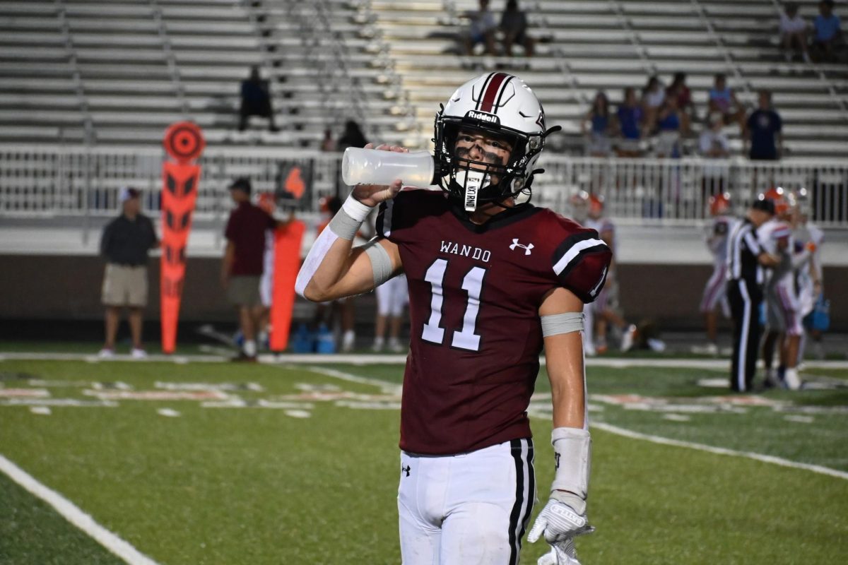 A football player rehydrates after a play.