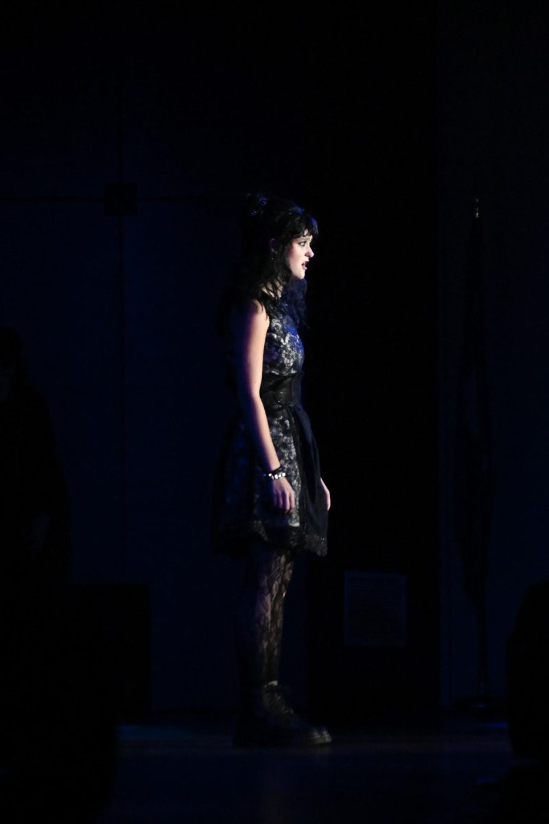 Junior Mia Bott stands centerstage alone performing as the lead Lydia Deetz in Beetlejuice Jr. 