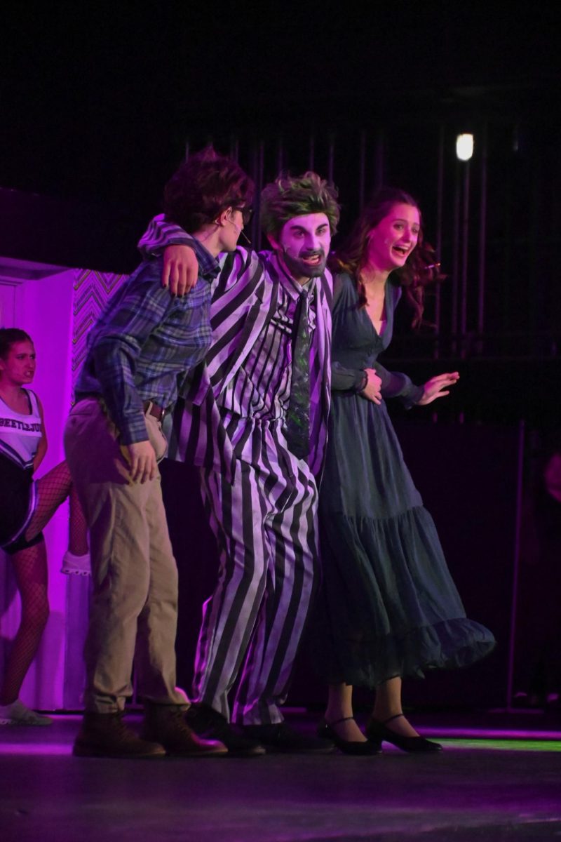 Senior Jeremy Rokos (center) as Beetlejuice brings in both the Maitland Characters. Senior Wynnie Allee (right) as Barbara seems surprised. 