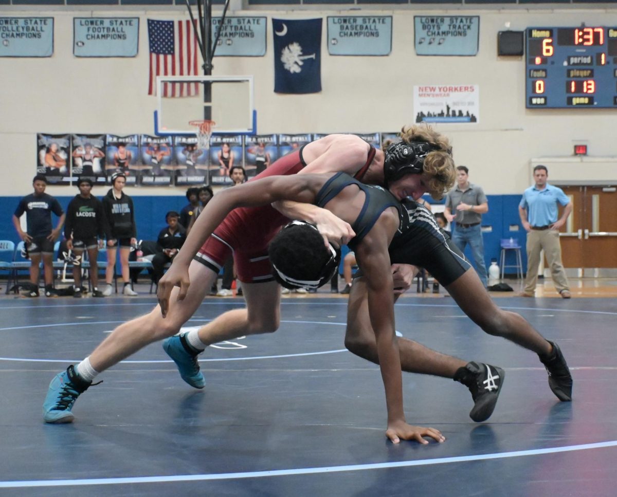 Junior Trenton Harvey struggles as he goes in to take his opponent down for a pin