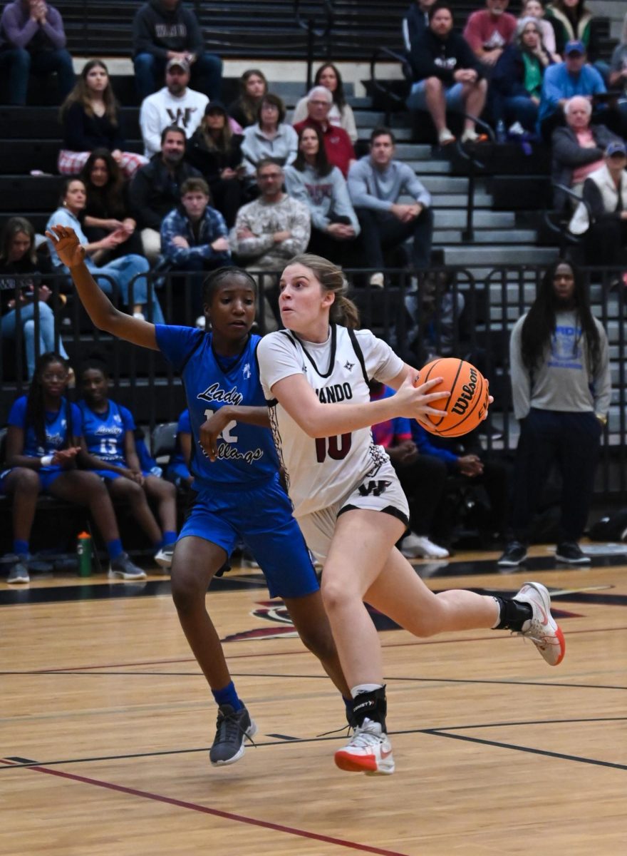  Senior Riley Craft drives to the basket against contact to score for her team. “I was trying to finish up the rim on my left side to score,” said Craft. 
