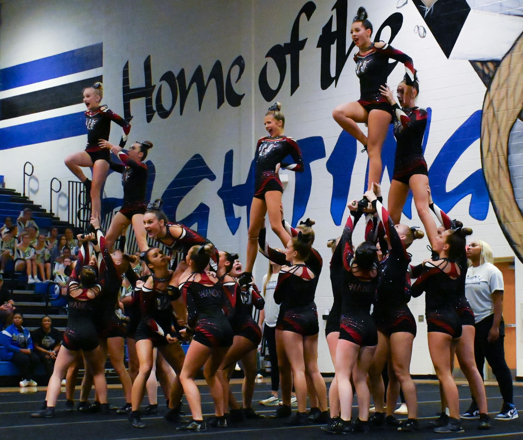 Sophomore Emary Daniel is held up by her teammates while performing a cheer routine.