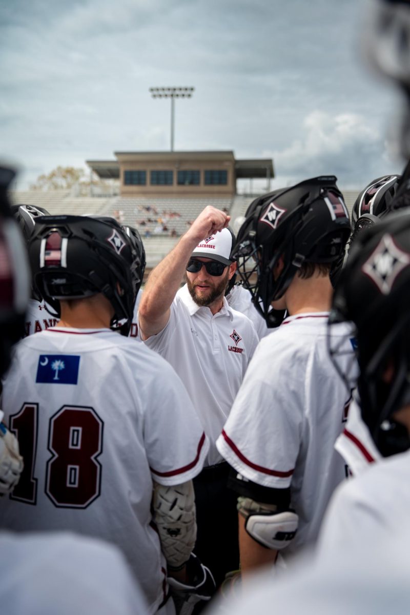 Head Coach Lance Renes ends a huddle with the team before the game, calling for good and clean play.