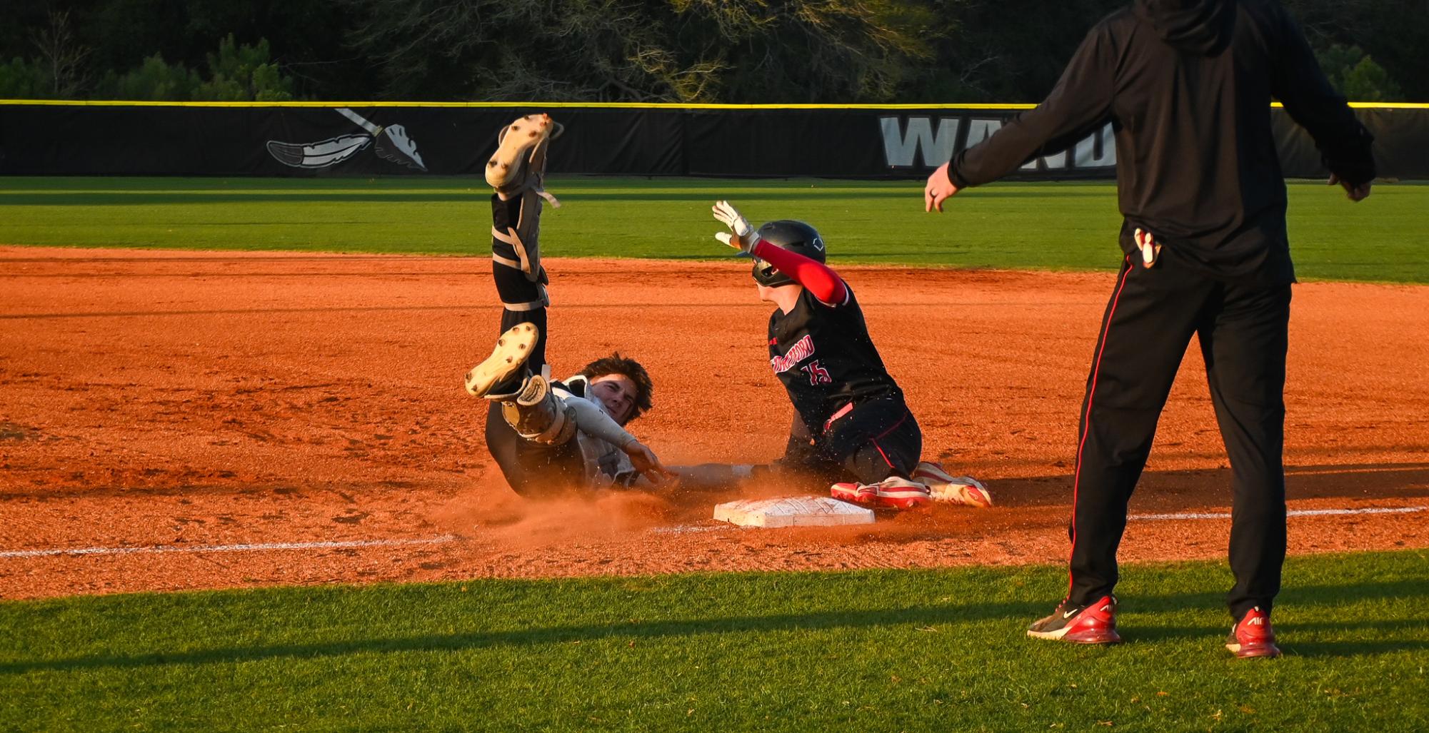 Junior catcher Jake DiMartino slides into first base to get the out. 