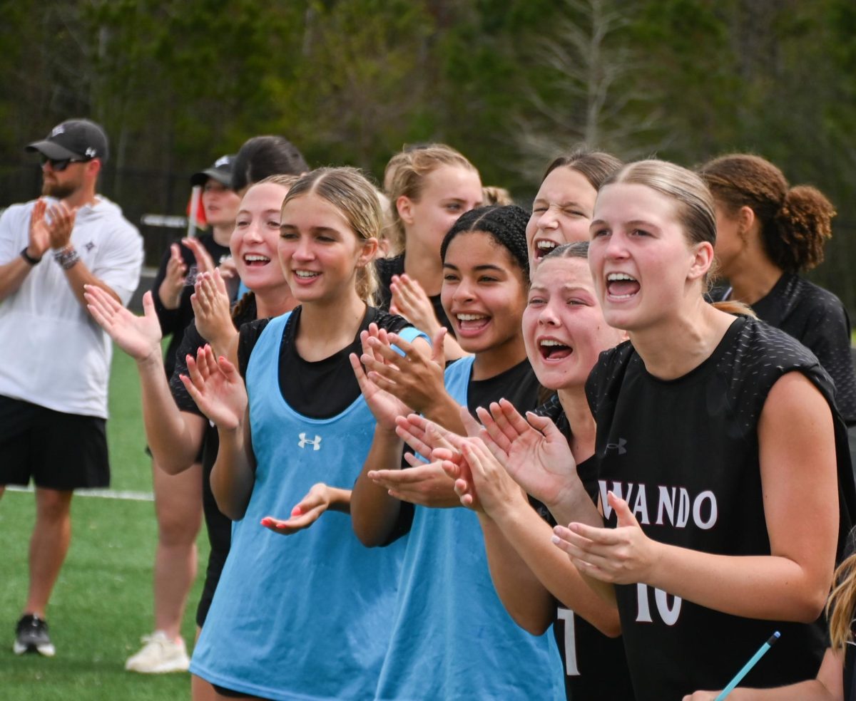 Sophomore Foward Zoey Carter, Sophomore Defender Abbie Shaw, and their teammates cheer during penalty kicks.