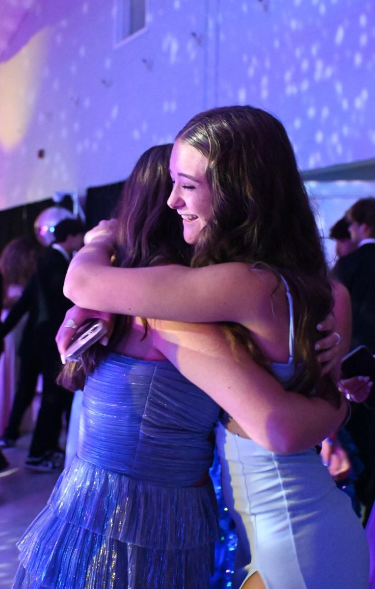 Junior Mia E. embrasses her friend in a hug at prom.