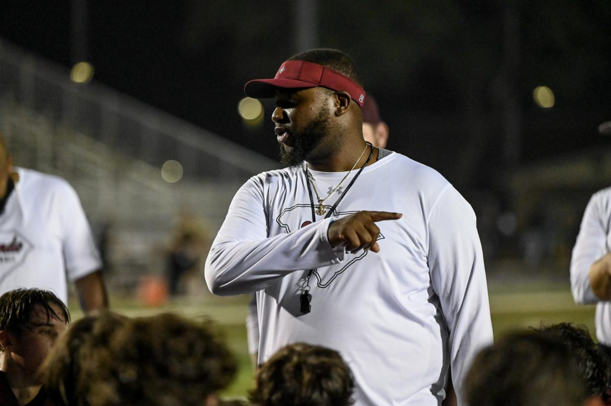 Head football coach Isaiah Perrin speaks to the team after a showcase first home win against the Socastee football team.