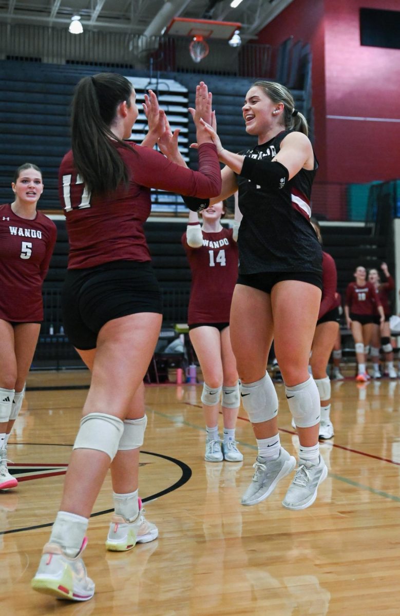 Senior Libero Violet Poole high fives her teammate Senior Right Side Hitter Anna Welch. 