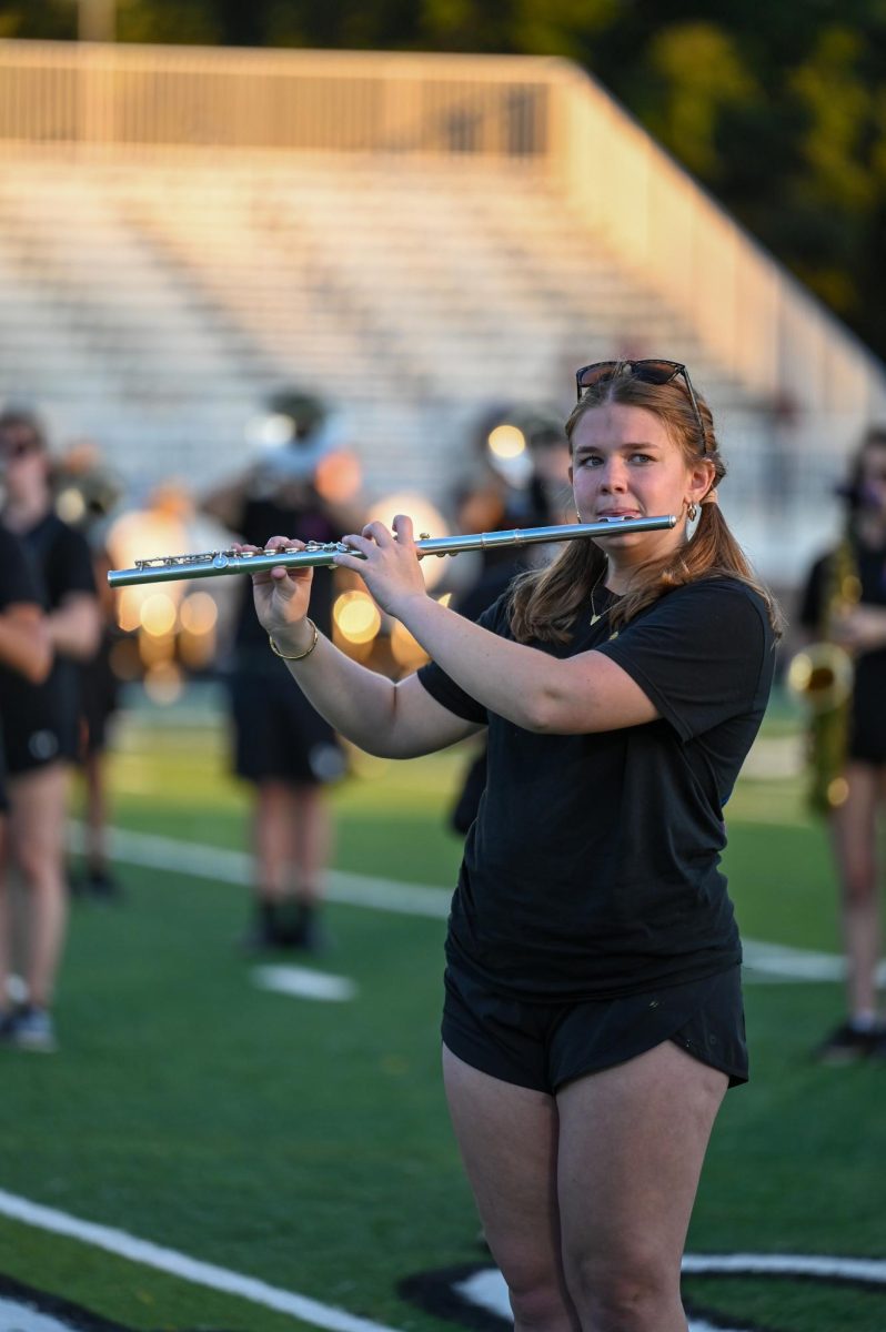 Junior Maria Lambert plays her instrument on the field.   