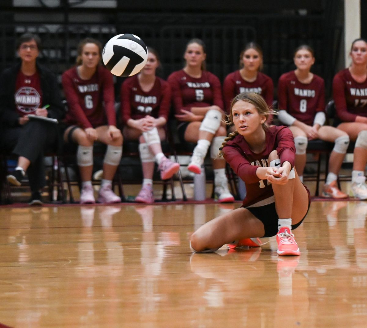 Sophomore Setter Maddie Hopper crouches down to bump the ball.
