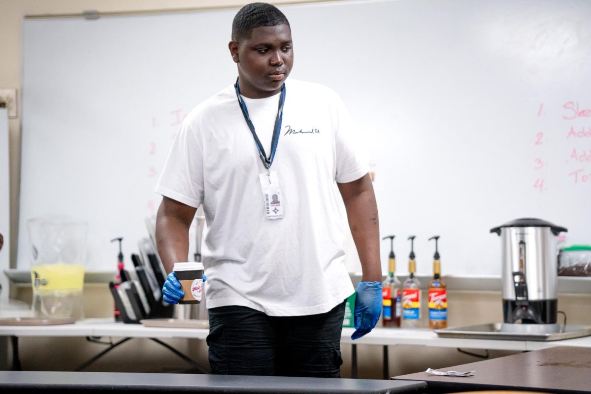 Junior Josh President-Nelson serves a coffee to student customers before the beginning of school. Adviser Kim Prentice hopes that this opprotunity can provide future benefits for these students, “We teach job skills here, so that they can get their own jobs in  the future,” Prentice said